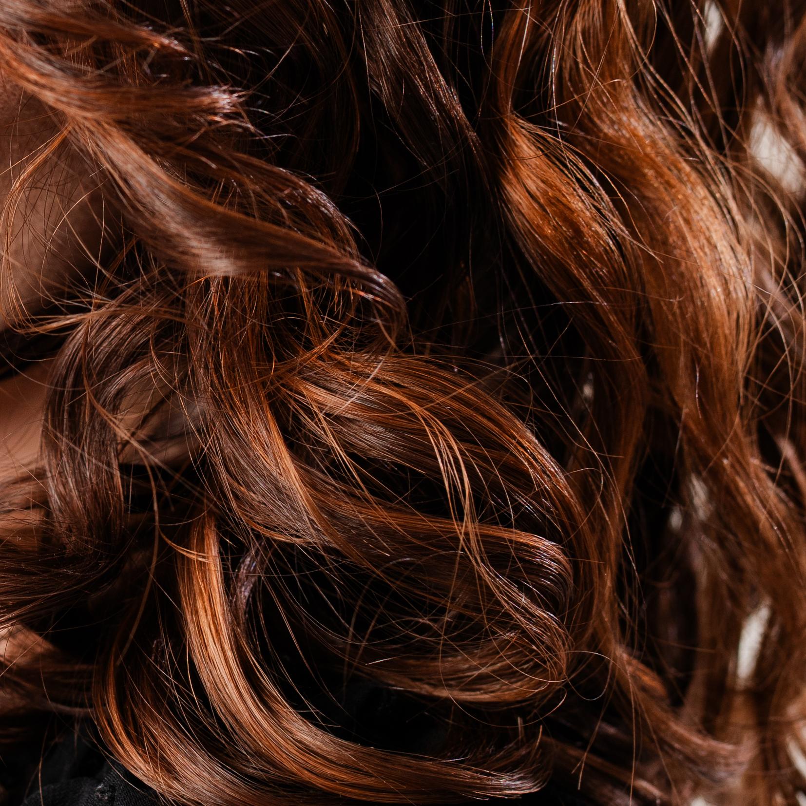 Detailporträt von braunen Locken mit Pony und natürlicher Lockenstruktur